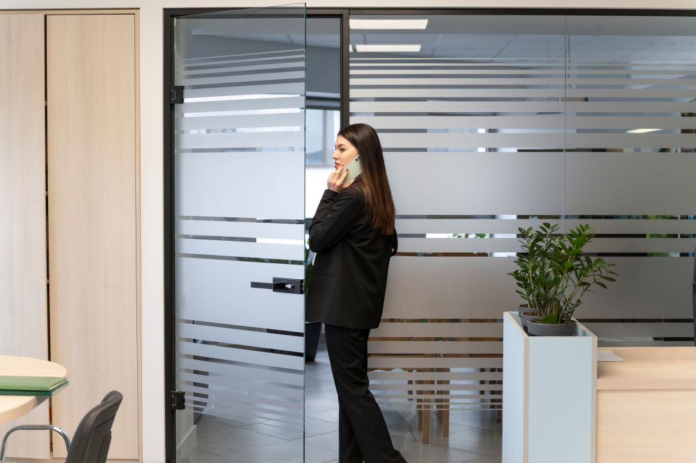 Businesswoman walking through office with custom 3M Frosted Window Film installed