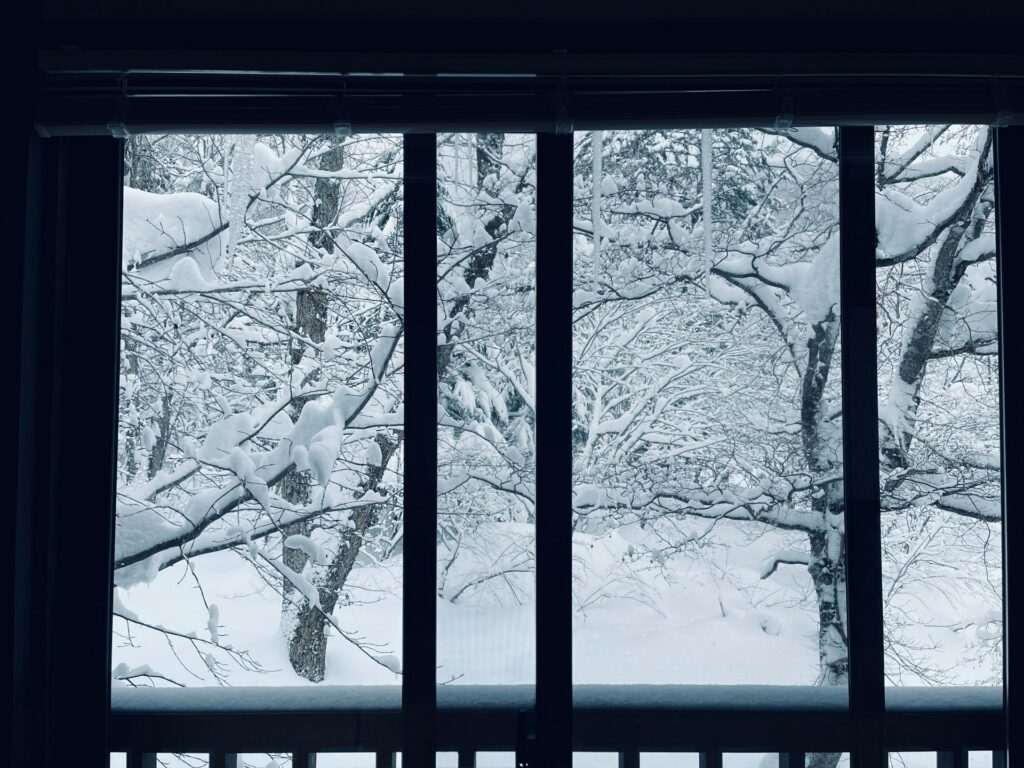 Empty desk beside a floor-to-ceiling office window on a grey winter morning in Seattle